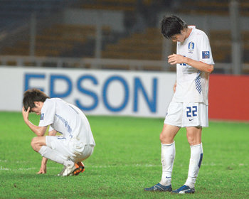 ‘고개 숙인 한국 축구.’ 한국의 김정우(왼쪽)와 강민수가 약체 바레인에 충격의 1-2 역전패를 당한 뒤 고개를 숙인 채 침통한 표정을 짓고 있다. 자카르타=연합뉴스