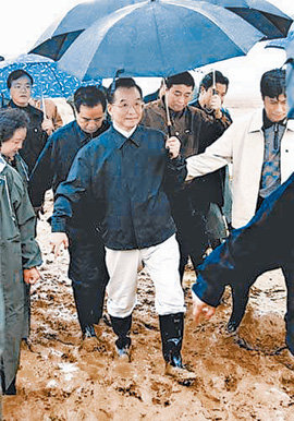 손수 우산을 들고 수해 현장을 시찰하고 있는 원자바오 총리(가운데).