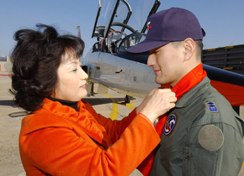 이 어머니의 슬픔은… 지난해 2월 경북 예천군의 공군 제16전투비행단에서 열린 고등비행교육 수료식에서 박인철 대위(당시 중위·오른쪽)에게 어머니가 ‘빨간 마후라’를 매어 주고 있다. 사진 제공 공군