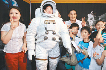 10일 경기 고양시 킨텍스의 ‘2007 대한민국 과학축전’을 찾은 한국 최초의 우주인 후보 이소연 씨(왼쪽)와 고산 씨(오른쪽 뒤)가 우주복을 입은 어린이와 함께 기념 촬영을 하고 있다. 고양=최혁중  기자