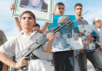 2004년 이라크 바그다드에서 열린 한 시위에 AK-47 소총을 든 채 참가한 소년. 이런 소년 전사들을 다시 건전한 10대 청소년으로 교화시키기 위한 프로그램이 최근 이라크 내 수용소에서 가동 중이다. 동아일보 자료 사진