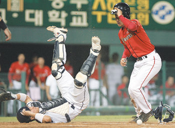 홈서 대충돌23일 열린 SK-두산 경기 4회초 2사 만루에서 SK 2루 주자 최정(오른쪽)이 정근우의 적시타 때 간발의 차로 홈을 밟고 있다. 두산 포수 채상병은 최정과 부딪칠 때 넘어지면서 볼을 떨어뜨렸다. 연합뉴스