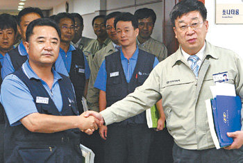 손잡은 노사 4일 현대자동차 울산공장 본관 1층에서 윤여철 사장(오른쪽)과 이상욱 노조 지부장이 임금 단체협상 잠정 합의안을 마련한 뒤 악수하고 있다. 울산=최재호기자