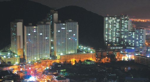 불꺼진 아파트… 캄캄한 주택시장  10일 부산 사하구 장림동에 최근 완공된 아파트(사진 왼쪽)의 대부분이 불이 꺼진 채 빈집으로 남아 있다. 이 아파트는 650채 가운데 절반가량만 분양됐다. 부산=최재호  기자