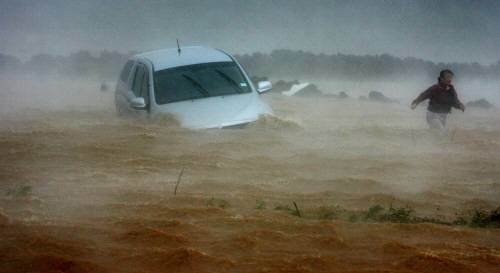 16일 제11호 태풍 ‘나리’가 제주지방을 강타한 가운데 물에 제주시 한림읍 수원리 입구 일주도로 변에서 한 여성운전자가 웅덩이에 빠진 차량을 버리고 대피하고 있다.[연합]