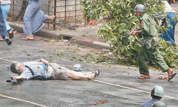 나가이 겐지 일본 APF통신 기자(왼쪽)가 27일 시위 현장에서 쓰러져 총에 맞은 직후에도 시위 진압 군경을 바라보고 있다. 오른쪽 가슴에 총에 맞은 자국이 선명하며 오른손에는 취재용 캠코더를 들고 있다. 양곤=로이터 연합뉴스