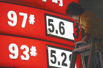 中 휘발유값 10% 인상1일 중국 쓰촨 성 청두 시의 한 주유소 직원이 오른 휘발유 가격을 가격표에 표시하고 있다. 중국이 지난달 31일 휘발유와 디젤유 가격을 10% 가까이 기습 인상하면서 유가대란이 우려되고 있다. 청두=로이터 연합뉴스