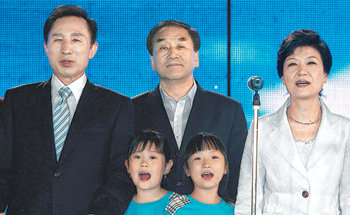 8월 20일 한나라당 경선 결과 발표 직후 대선 후보로 결정된 이명박 당선자(왼쪽)가 박근혜 전 대표와 함께 화합을 다짐하는 노래를 부르고 있다. 가운데는 이재오 당시 한나라당 최고위원. 동아일보 자료 사진