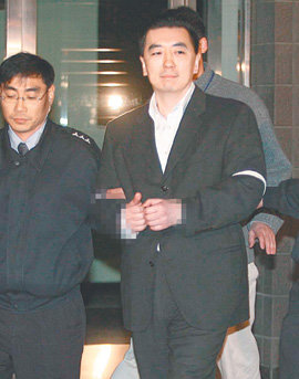 구치소 가는 김 씨 특정경제범죄가중처벌법상 횡령 등 혐의로 구속영장이 발부된 김경준 씨(오른쪽)가 19일 0시 12분경 서울중앙지검 청사를 나와 경기 의왕시 서울구치소로 향하고 있다. 양팔이 포승으로 묶이고, 손에 수갑을 찬 김 씨는 16, 17일과는 달리 아무런 말도 하지 않았다. 원대연기자