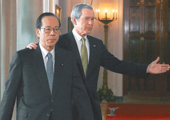미국을 방문한 후쿠다 야스오 일본 총리(왼쪽)가 16일 백악관에서 미일 정상회담 결과를 설명하는 짤막한 공동기자회견을 마친 뒤 조지 W 부시 대통령의 안내로 자리를 옮기고 있다. 워싱턴=로이터 연합뉴스