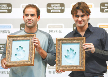 ‘신구 테니스 황제’ 로저 페데러(오른쪽)와 피트 샘프러스가 맞대결을 하루 앞둔 19일 서울 여의도 현대카드 본사에서 열린 기자회견을 마친 뒤 자신들의 핸드프린팅을 들고 포즈를 취하고 있다. 연합뉴스