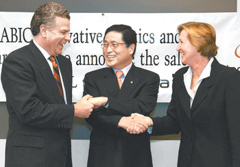 최웅진 한화L&C 사장(가운데)이 20일 미국 뉴욕에서 아즈델의 지분 인수 계약을 마친 후 빅토리아 홀트 PPG사 부사장(오른쪽)과 그레고리 아담스 새빅이노버티브플라스틱스 부사장과 함께 악수하고 있다. 사진제공 한화그룹