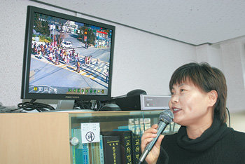 4일 오후 경기 양주시 신지초등학교 강금순 교사가 행정실에 있는 모니터로 학생들의 하굣길 상황을 살펴보며 마이크로 학생들을 지도하고 있다. 이동영 기자