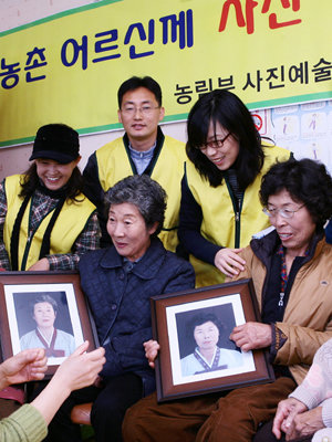 2006년 11월 충남 홍성지역 할머니들이 농림부 직원들이 찍어준 사진을 받으며 즐거워하고 있다. 사진 제공 농림부 사진예술연구회