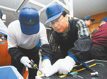 김종갑 하이닉스반도체 사장(왼쪽에서 두 번째)이 18일 일본 도요타자동차 히라야마 공장의 기술연수센터에서 라디에이터 조립공정에 대한 실습을 하고 있다. 사진 제공 하이닉스반도체