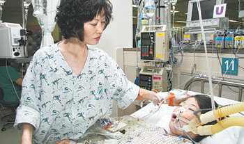 문점선 씨(왼쪽)가 심장 이식을 받기 전 병원 내 소아중환자실에서 사경을 헤매는 아들 전호진 군을 돌보고 있다. 사진 제공 서울아산병원