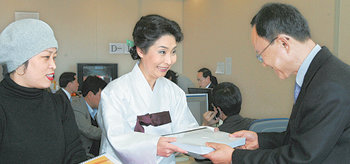 “취임식 때 한복 입으세요”원혜은 한국한복공업협동조합 이사장(가운데)이 15일 대통령취임준비위원회를 방문해 전택수 준비위원에게 “이명박 대통령 당선인이 25일 취임식 때 한복을 입어 달라”는 요청서에 서명한 한복업 종사자의 명단을 전달했다. 이 당선인은 취임식 때 한복을 입기로 했다. 연합뉴스