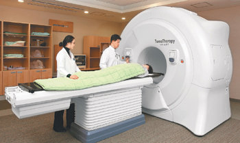 의료진이 방사선 세기가 조절되는 방사선기기에 컴퓨터단층촬영(CT) 기능을 추가한 토모세러피를 이용해 뇌암 환자를 치료하고 있다. 토모세러피는 신체의 미세한 움직임까지 계산해서 암 부위에 정확하게 방사선을 쪼여 준다. 사진 제공 삼성암센터