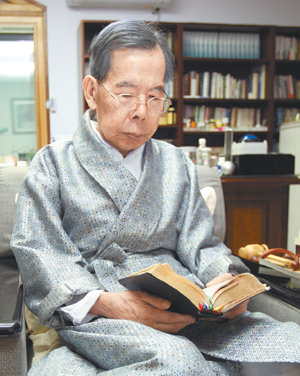 김수환 추기경이 18일 오후 서울 종로구 혜화동 주교관 집무실에서 성서를 읽으며 묵상에 잠겨 있다. 지난해 12월 한 달간 입원했던 김 추기경은 퇴원 후 처음으로 동아일보와 인터뷰를 했다. 편안한 복장에 영양제 주사를 맞고 있던 김 추기경은 사진촬영을 위해 실내용 가운을 입었다. 전영한  기자