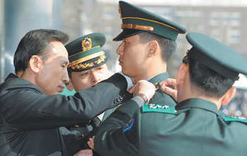 이명박 대통령이 28일 경기 성남시 학생중앙군사학교 연병장에서 열린 학군장교 임관식에서 육해공군 및 해병대 대표 4명에게 계급장을 달아 주고 있다. 성남=이종승  기자