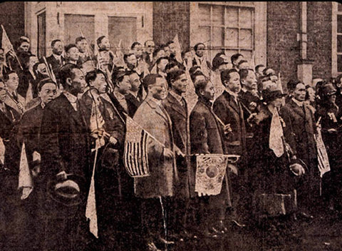 1919년 4월 16일 필라델피아 시가 행진을 마치고 주 의회 의사당(독립기념관)에 도착한 한인들. 앞줄 오른쪽에서 네번째 키 큰 남자(깃발 들고 있는 여자의 오른쪽)가 서재필 선생이다.사진제공 서재필기념재단(필라델피아 소재)