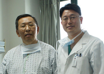전 몽골 교육과학장관인 차강 씨가 3일 자신의 간 이식 수술을 집도한 이광웅 박사(오른쪽)와 함께 기념사진을 찍고 있다. 사진 제공 국립암센터