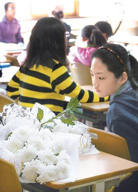 “친구야, 잘가라”이혜진 양이 다니던 경기 안양시 명학초등학교의 한 학생이 14일 교실에서 숨진 이 양의 빈자리에 놓인 국화를 안타깝게 바라보고 있다. 안양=원대연 기자