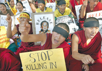 “학살 중단하라”티베트인 망명자들이 16일 인도 뉴델리에서 ‘학살 중단’ 등이 쓰인 플래카드를 든 채 중국 정부의 유혈 진압을 비판하는 연좌시위를 벌이고 있다. 뉴델리=로이터 연합뉴스