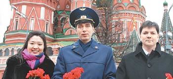 한국 최초로 우주선에 오를 이소연 씨(왼쪽)가 19일 러시아 모스크바 붉은광장에서 꽃다발을 들고 활짝 웃고 있다. 이 씨 옆에는 국제우주정거장에 함께 갈 러시아 우주인 세르게이 볼코프 씨(가운데)와 올레그 코노넨코 씨. 모스크바=로이터 연합뉴스