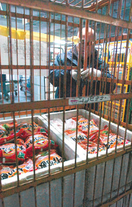 1월 일본 미야기 현의 냉동식품 판매회사가 문제가 된 중국산 ‘농약만두’를 회수해 보관하는 모습. 실수로 유통되는 일이 없도록 철망안에 넣어 자물쇠를 채우고 있다. 사진 제공 아사히신문