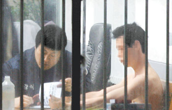 26일 박정희 전 대통령 생가보존회장 김재학 씨를 흉기로 찔러 숨지게 한 혐의를 받고 있는 용의자 강모 씨(오른쪽)가 구미경찰서에서 조사를 받고 있다. 구미=전영한 기자