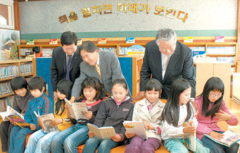 2일 전남 강진군 칠량초등학교 학교마을도서관. 개관식에 참석한 박남영 강진교육장, 황주홍 강진군수, 김수연 작은 도서관 만드는 사람들 대표(뒷줄 왼쪽부터)가 짬을 내 아이들의 책 읽기를 살폈다. 사진 제공 작은 도서관 만드는 사람들