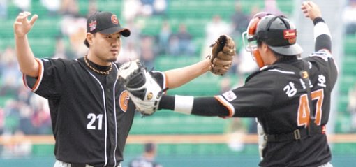 롯데 선발 송승준(왼쪽)이 9회말 LG 4번 타자 최동수를 우익수 뜬공으로 잡고 7-0 완봉승을 거둔 뒤 포수 강민호와 기쁨의 포옹을 하려 하고 있다. 연합뉴스