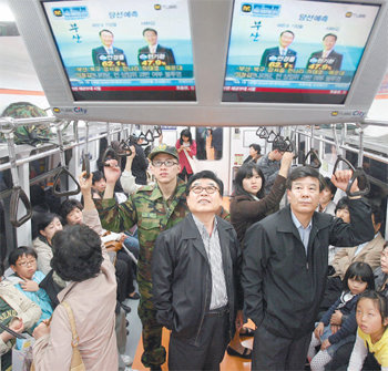 쏠린 눈서울 지하철 3호선에 탄 승객들이 9일 오후 객차 내에 설치된 모니터를 통해 방송사들의 선거 출구조사 결과를 지켜보고 있다. 연합뉴스