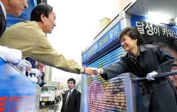 “당선 축하합니다”한나라당 박근혜 전 대표(오른쪽)가 10일 지역구인 대구 달성군에서 당선사례 도중 이웃 지역구(달서구)에서 당선사례 중이던 측근인 무소속 이해봉 의원과 우연히 마주치자 활짝 웃으며 악수로 이 의원의 당선을 축하하고 있다. 대구=연합뉴스