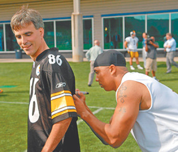 지난해 10월 북미프로미식축구리그(NFL) 피츠버그 스틸러스 팀과 깜짝 훈련을 한 랜디 포시 미국 카네기멜런대 교수의 유니폼에 하인스 워드가 사인을 해 주고 있다. 사진 출처 피츠버그트리뷴리뷰