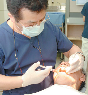 치과 의사가 임플란트 시술을 받은 부위에 염증이 생기는 것을 막기 위해 소독제를 주사하고 있다. 사진 제공 세브란스병원