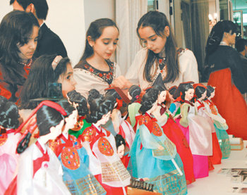 지난해 11월 이란 테헤란의 한국대사관에서 열린 드라마 대장금 종방 기념 리셉션에 참가한 이란인들. 대장금 열기를 반영이라도 하듯 한복을 입은 인형들을 흥미롭게 살펴보고 있다. 테헤란=윤완준  기자