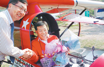 탐험가 허영호(오른쪽) 씨가 18일 경기 여주군 이글비행장에서 초경량 비행기를 타고 여주를 출발해 제주도를 돌아오는 국토 종단 왕복 비행에 성공한 뒤 축하를 받고 있다. 여주=연합뉴스