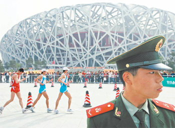 베이징 올림픽 주경기장이 처음 공개된 18일 새 둥지 모양의 ‘냐오차오’에서는 첫 경기로 국제육상경기연맹이 주최한 경보대회가 열렸다. 테러나 시위에 대비해 주위를 살피고 있는 중국 경찰의 눈초리가 날카롭다. 베이징=EPA 연합뉴스