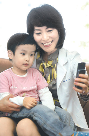 휴대전화로 나이 마흔에 낳은 셋째 아이와 사진을 찍고 있는 정지행 씨. 홍진환 기자