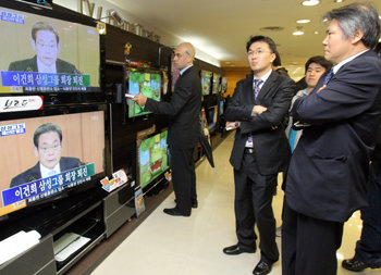 22일 서울 중구 태평로 삼성본관 지하 1층 가전매장을 찾은 취재진과 시민들이 TV 생중계를 통해 이건희 삼성그룹 회장의 퇴진 성명 발표를 지켜보고 있다. 원대연 기자