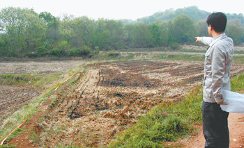 “바로 저 땅”인천경제자유구역청 직원이 2002년 6월 박미석 대통령사회정책수석비서관의 배우자 이모 씨 등 3명이 공동 매입한 인천 중구 운북동 26의 논을 가리키고 있다. 인천=황금천 기자