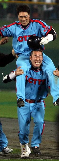 2-3으로 뒤진 연장 10회말 2사 1, 3루에서 끝내기 역전타를 터뜨린 롯데 조성환(위)이 동료 정수근의 어깨 위에 올라 축하를 받고 있다. 롯데 선수들이 옛 하늘색 유니폼을 입는 ‘Again 1984’ 행사가 벌어진 사직구장은 올해 네 번째 매진을 기록했다. 부산=연합뉴스