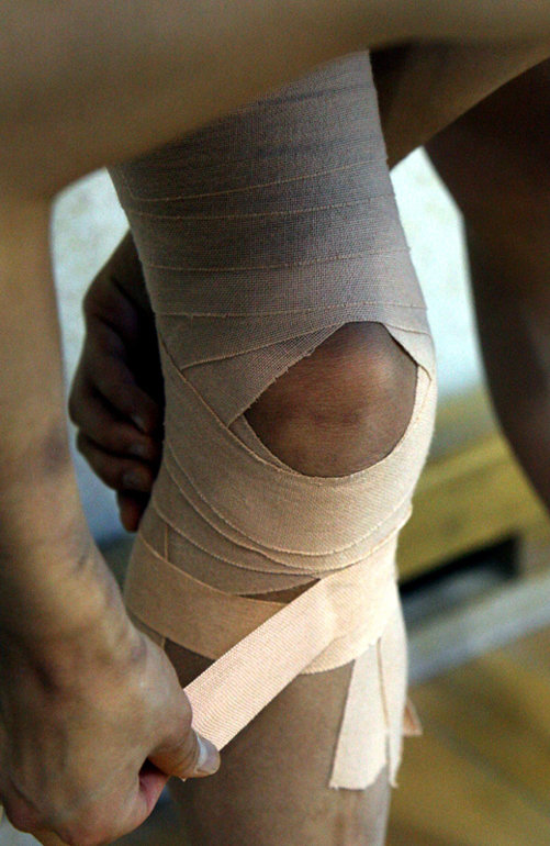 ▲그래도 훈련은 계속된다 아파도 훈련은 거를 수 없다. 한 체조 선수가 무픞 보호를 위해 테이핑을 하고 있다. 부상은 선수들의 가장 큰 적이다.
