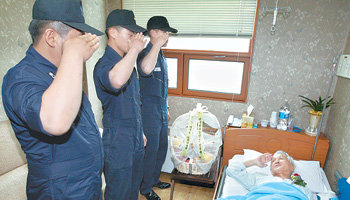 2002년 제2연평해전에서 전사한 윤영하 소령의 아버지 윤두호 씨(오른쪽)가 어버이날인 8일 아들의 후배 장교들에게서 카네이션을 받았다. 교통사고를 당해 경기 안산시의 한 병원에 입원 중인 윤 씨가 침대에 누운 채 해군 장교들의 거수경례에 답하고 있다. 안산=연합뉴스