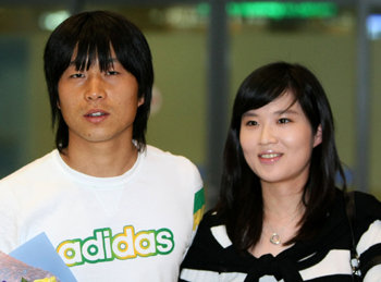 소속팀 웨스트브로미치의 승격으로 한국인 다섯 번째 잉글랜드 프리미어리거를 예약한 김두현(왼쪽)이 16일 부인 정혜원 씨와 함께 인천공항을 통해 귀국했다. 인천=연합뉴스