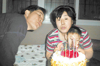 2004년 신봉재(왼쪽) 한정숙 씨 부부가 1급 장애아인 막내아들 영광 군과 함께 한 씨의 47번째 생일을 축하하고 있는 모습. 사진 제공 신봉재 씨