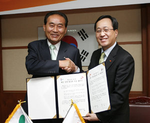 SK그룹 자원봉사단장인 김신배 SK텔레콤 사장(오른쪽)이 22일 충남 태안군청에서 진태구 태안군수와 ‘SK 태안 경제 활성화 지원 협약’을 맺은 뒤 악수를 하고 있다. 사진 제공 SK그룹