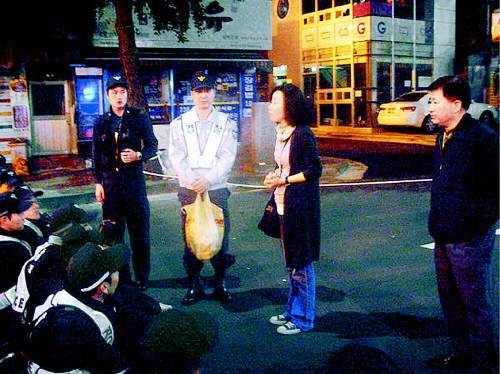7일 저녁 김영백 씨(오른쪽)와 예비역 전경을 자식으로 둔 한 어머니(가운데)가 대기 중인 의경들에게 격려의 말을 건네고 있다. 어머니의 옆에 서 있는 경찰이 들고 있는 것은 김 씨가 건넨 간식거리. 신진우 기자